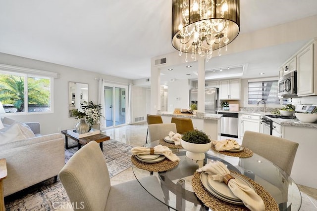28191 Sorrento Unit 111, Laguna Niguel, CA 92677 - dining room with healthy amount of natural light, a chandelier, and a raised ceiling