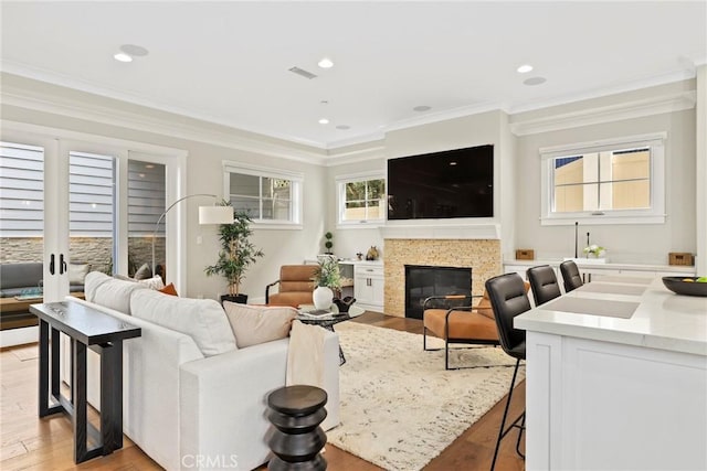 716 Elvira Ave Unit A, Redondo Beach, CA 90277 - living room featuring light wood-type flooring, crown molding, a glass covered fireplace, and recessed lighting