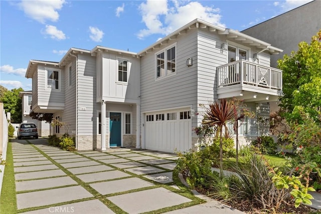 716 Elvira Ave Unit A, Redondo Beach, CA 90277 - view of front facade with a balcony, concrete driveway, an attached garage, and stone siding
