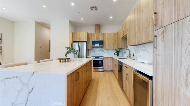 421 N Catalina St, Burbank, CA 91505 - kitchen featuring stainless steel appliances, beverage cooler, a kitchen island, light wood finished floors, and recessed lighting