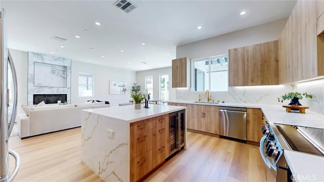 421 N Catalina St, Burbank, CA 91505 - kitchen with modern cabinets, appliances with stainless steel finishes, a kitchen island, light wood-style flooring, and recessed lighting