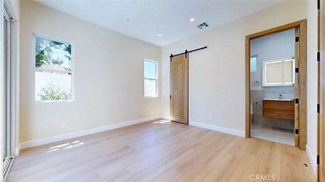 421 N Catalina St, Burbank, CA 91505 - unfurnished bedroom with a barn door, light wood finished floors, multiple windows, recessed lighting, and ensuite bathroom