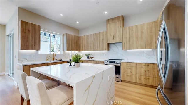 421 N Catalina St, Burbank, CA 91505 - kitchen featuring stainless steel appliances, modern cabinets, light brown cabinetry, a center island, and light wood-type flooring