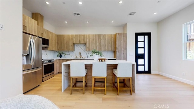 421 N Catalina St, Burbank, CA 91505 - kitchen featuring appliances with stainless steel finishes, light countertops, modern cabinets, a breakfast bar, and a center island