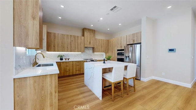 421 N Catalina St, Burbank, CA 91505 - kitchen featuring appliances with stainless steel finishes, a kitchen breakfast bar, a kitchen island, recessed lighting, and light countertops