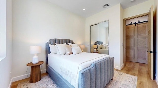 421 N Catalina St, Burbank, CA 91505 - bedroom with light wood-style floors, a closet, a barn door, and recessed lighting