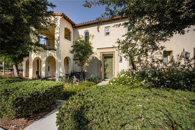 8495 E Preserve Loop, Chino, CA 91708 - mediterranean / spanish house featuring a balcony, stucco siding, a front lawn, and a tiled roof