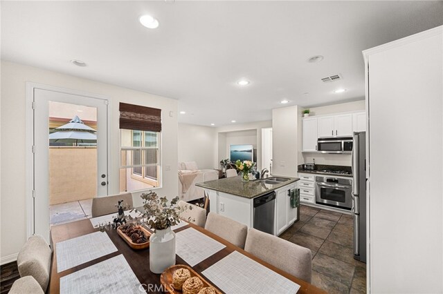 8495 E Preserve Loop, Chino, CA 91708 - kitchen featuring appliances with stainless steel finishes, dark countertops, white cabinets, an island with sink, and recessed lighting