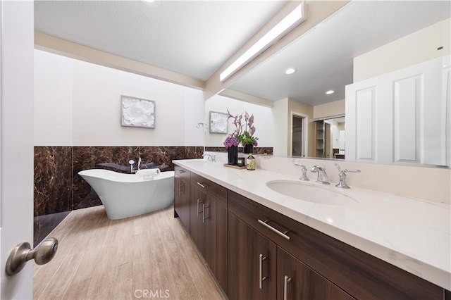 15 Valley Vw, Irvine, CA 92612 - full bathroom featuring double vanity, a freestanding bath, tile walls, wainscoting, and wood finished floors