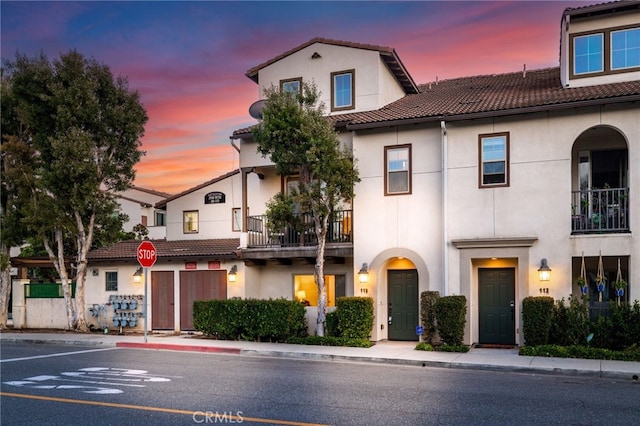 2950 19th St Unit 113, Signal Hill, CA 92707 - view of front of house with a tile roof, stucco siding, and a balcony