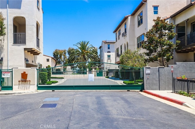 2950 19th St Unit 113, Signal Hill, CA 92707 - view of asphalt road featuring curbs, a gate, and sidewalks