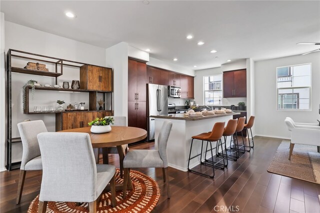 2950 19th St Unit 113, Signal Hill, CA 92707 - kitchen featuring appliances with stainless steel finishes, dark wood-type flooring, a kitchen breakfast bar, a kitchen island, and recessed lighting