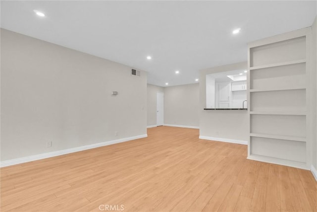 600 W 3rd St Unit C207, Santa Ana, CA 92701 - unfurnished living room featuring light wood-style flooring, recessed lighting, and built in features