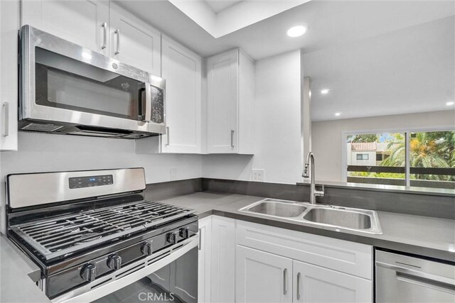 600 W 3rd St Unit C207, Santa Ana, CA 92701 - kitchen with stainless steel appliances, white cabinets, recessed lighting, and dark countertops