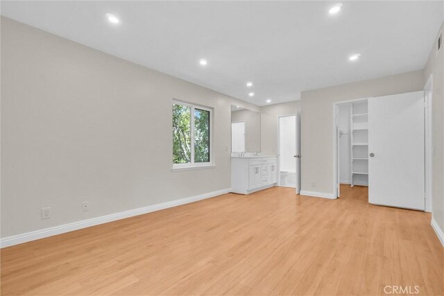 600 W 3rd St Unit C207, Santa Ana, CA 92701 - unfurnished bedroom featuring a walk in closet, light wood-style floors, and recessed lighting