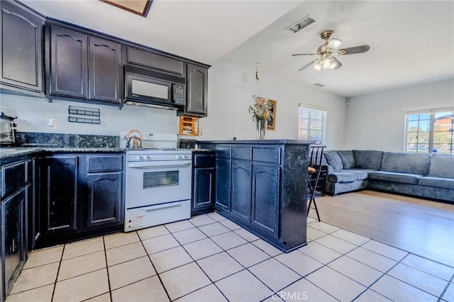 13018 Rosecrans Ave, Norwalk, CA 90650 - kitchen with black microwave, white range with gas cooktop, a peninsula, and healthy amount of natural light