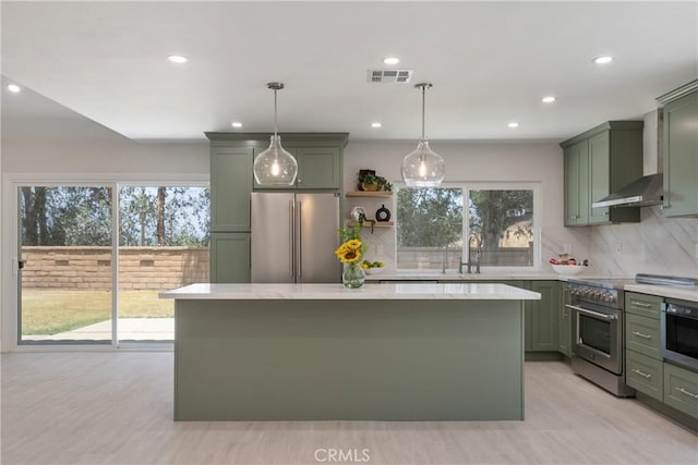 22 Sage Cyn, Pomona, CA 91766 - kitchen featuring green cabinets, appliances with stainless steel finishes, wall chimney range hood, decorative backsplash, and recessed lighting