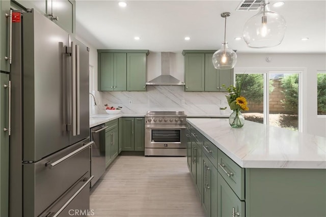 22 Sage Cyn, Pomona, CA 91766 - kitchen with green cabinets, premium appliances, wall chimney exhaust hood, backsplash, and light wood finished floors