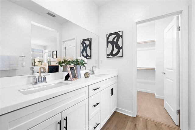 944 N Divino Privado Unit 57, Ontario, CA 91764 - full bathroom featuring double vanity, wood finished floors, and a walk in closet