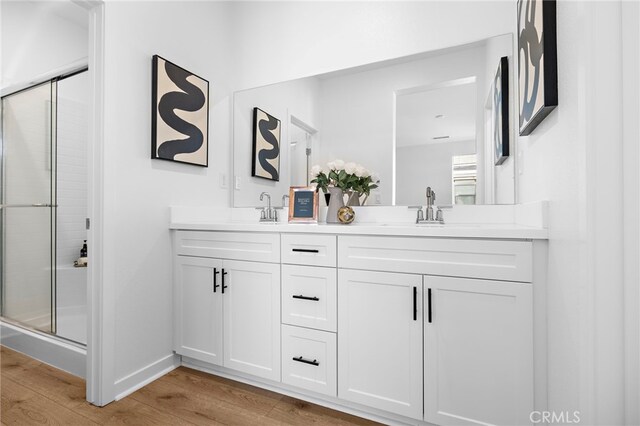 944 N Divino Privado Unit 57, Ontario, CA 91764 - full bathroom featuring double vanity, wood finished floors, and a stall shower