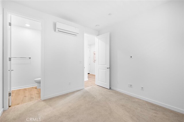 944 N Divino Privado Unit 57, Ontario, CA 91764 - unfurnished bedroom featuring a wall mounted AC, light colored carpet, and connected bathroom