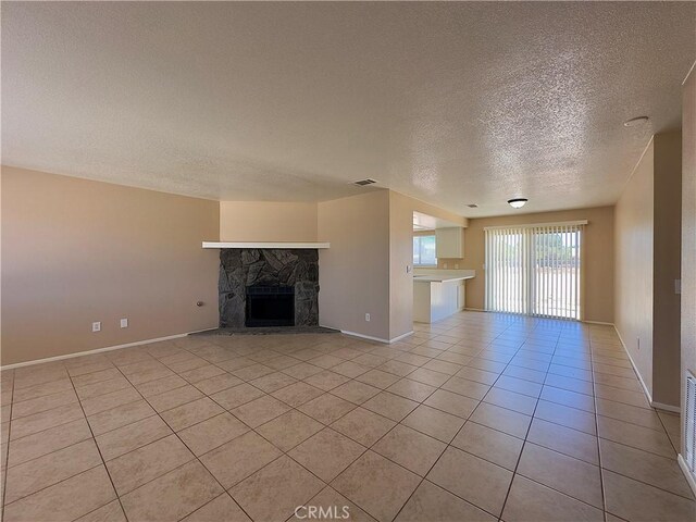 22241 Cholena Rd, Apple Valley, CA 92307 - unfurnished living room featuring a textured ceiling, light tile patterned flooring, and a stone fireplace