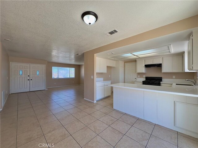 22241 Cholena Rd, Apple Valley, CA 92307 - kitchen with black gas range, under cabinet range hood, open floor plan, light countertops, and a textured ceiling