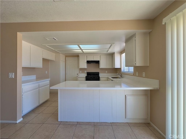 22241 Cholena Rd, Apple Valley, CA 92307 - kitchen featuring black gas range, a peninsula, light countertops, light tile patterned floors, and range hood