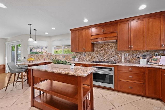 9481 Deanly St, Lakeside, CA 92040 - kitchen with stainless steel appliances, brown cabinets, light tile patterned floors, tasteful backsplash, and pendant lighting