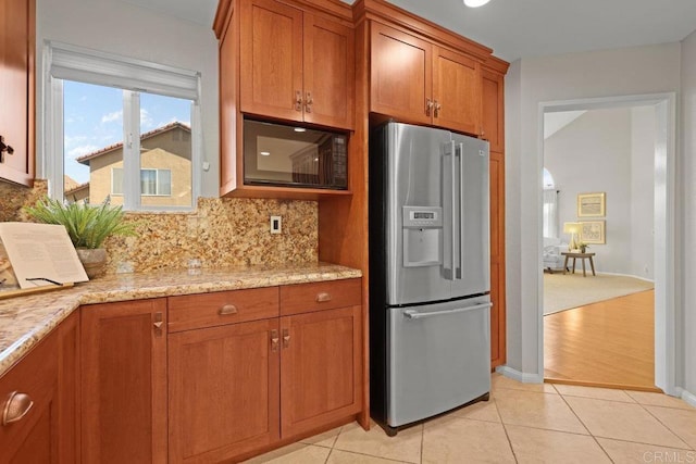 9481 Deanly St, Lakeside, CA 92040 - kitchen with stainless steel refrigerator with ice dispenser, black microwave, brown cabinets, decorative backsplash, and light stone countertops