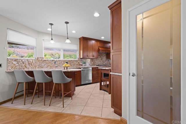 9481 Deanly St, Lakeside, CA 92040 - kitchen with stainless steel dishwasher, tasteful backsplash, a kitchen bar, a peninsula, and light stone counters
