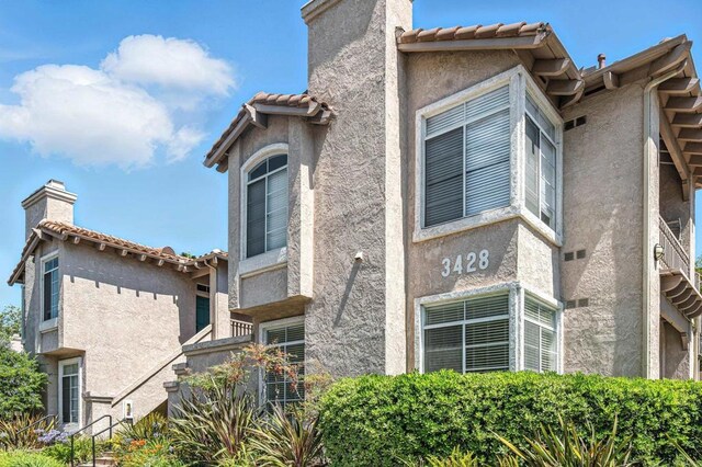 3428 Cameo Dr # 49, Oceanside, CA 92056 - view of home's exterior with stucco siding, a chimney, and a tiled roof