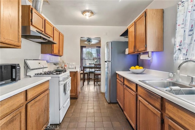 1932 S Orange Ave, West Covina, CA 91790 - kitchen featuring gas range gas stove, under cabinet range hood, light countertops, black microwave, and dark tile patterned flooring