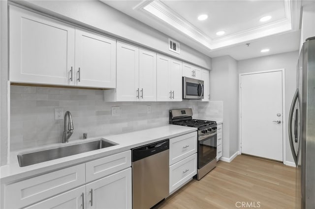 41 Breakers Ln, Aliso Viejo, CA 92656 - kitchen featuring stainless steel appliances, crown molding, light wood-type flooring, white cabinets, and a raised ceiling