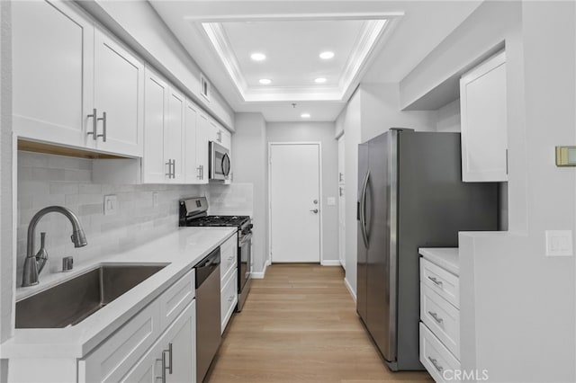 41 Breakers Ln, Aliso Viejo, CA 92656 - kitchen featuring appliances with stainless steel finishes, ornamental molding, a raised ceiling, tasteful backsplash, and white cabinetry