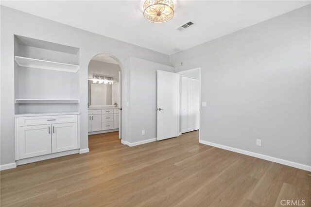 41 Breakers Ln, Aliso Viejo, CA 92656 - unfurnished bedroom featuring light wood-style floors, connected bathroom, and arched walkways