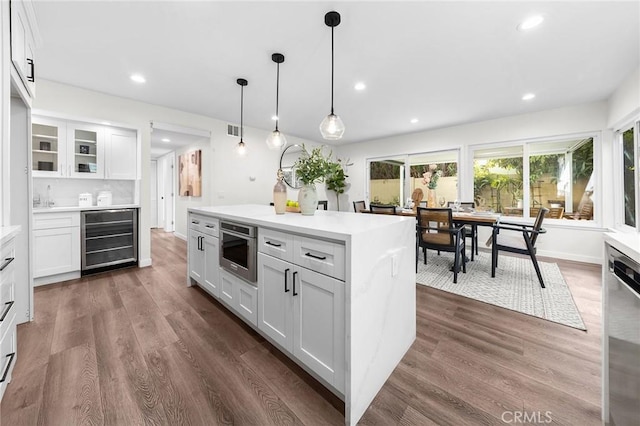 11685 Lakia Dr, Cypress, CA 90630 - kitchen featuring wine cooler, light countertops, dark wood-type flooring, white cabinetry, and recessed lighting