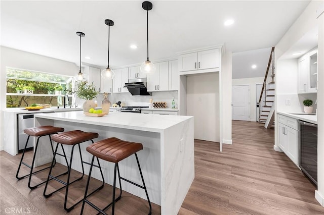 11685 Lakia Dr, Cypress, CA 90630 - kitchen featuring stainless steel dishwasher, white cabinets, recessed lighting, and light wood finished floors