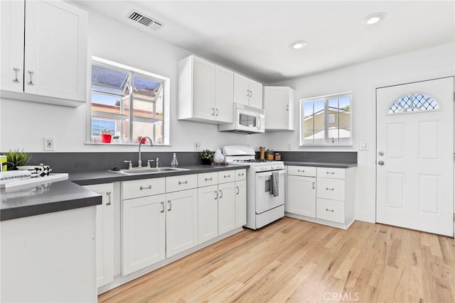 1742 253rd St, Lomita, CA 90717 - kitchen with white appliances, dark countertops, white cabinets, light wood-style floors, and recessed lighting