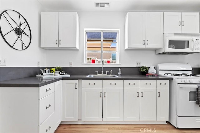1742 253rd St, Lomita, CA 90717 - kitchen featuring white appliances, dark countertops, white cabinetry, and light wood finished floors