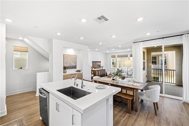 1281 Windmill Rd, Rancho Mission Viejo, CA 92694 - kitchen featuring light wood finished floors, light countertops, an island with sink, recessed lighting, and white cabinets