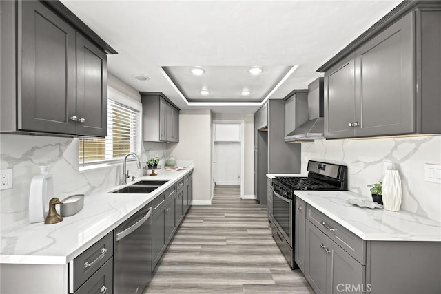 931 W Duarte Rd Unit 6, Arcadia, CA 91007 - kitchen featuring appliances with stainless steel finishes, wall chimney exhaust hood, a tray ceiling, backsplash, and recessed lighting