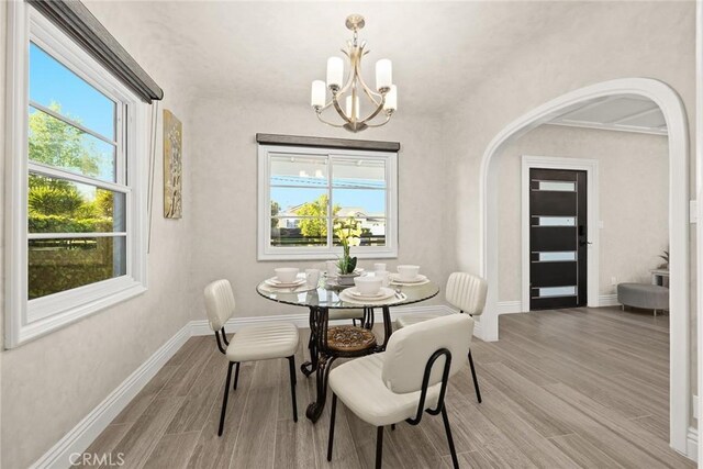 10210 Green St Unit 10210B, Temple City, CA 91780 - dining area featuring arched walkways, wood finished floors, a chandelier, and plenty of natural light