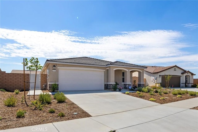 1943 Auger Pl, Hemet, CA 92545 - view of front facade with a garage, stucco siding, driveway, a porch, and stone siding