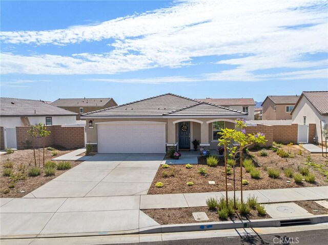 1943 Auger Pl, Hemet, CA 92545 - view of front of home featuring stucco siding, a garage, driveway, a tile roof, and covered porch