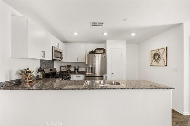 1943 Auger Pl, Hemet, CA 92545 - kitchen featuring stainless steel appliances, dark stone counters, a peninsula, white cabinetry, and recessed lighting