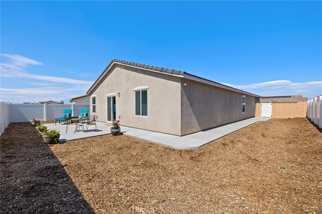 1943 Auger Pl, Hemet, CA 92545 - rear view of house with a patio, a fenced backyard, and stucco siding
