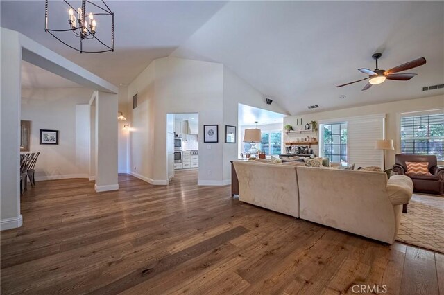 770 Warbler Ct, Merced, CA 95340 - living room featuring wood finished floors, a chandelier, a ceiling fan, high vaulted ceiling, and a multi sided fireplace