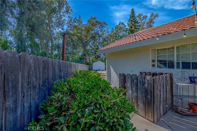 770 Warbler Ct, Merced, CA 95340 - view of side of property with stucco siding, a tile roof, and a storage unit