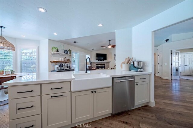770 Warbler Ct, Merced, CA 95340 - kitchen with stainless steel dishwasher, a ceiling fan, dark wood-style flooring, a fireplace, and recessed lighting